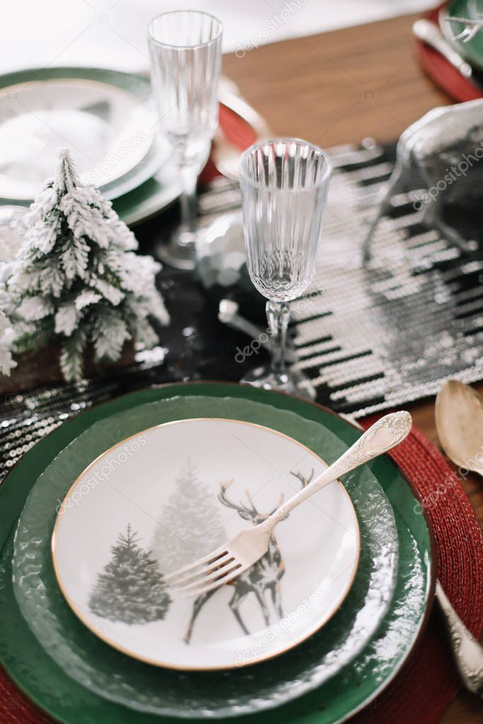 Festive table setting for Christmas dinner at home. New year and Christmas decorations. Winter holiday theme. Happy New Year.