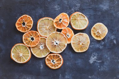 Üst görünüm kuru portakallar ve mandalinadan oluşan düz bir düzenleme. Gıda deseni koyu arka planda. Noel kompozisyonu