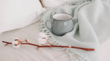 Coffee cup and cotton twig. Breakfast in bed. Cozy home. flat lay, still life.