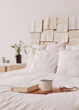 Spring still life. Breakfast in bed. White bedroom. Sweet home. Books and coffee cup. flat lay