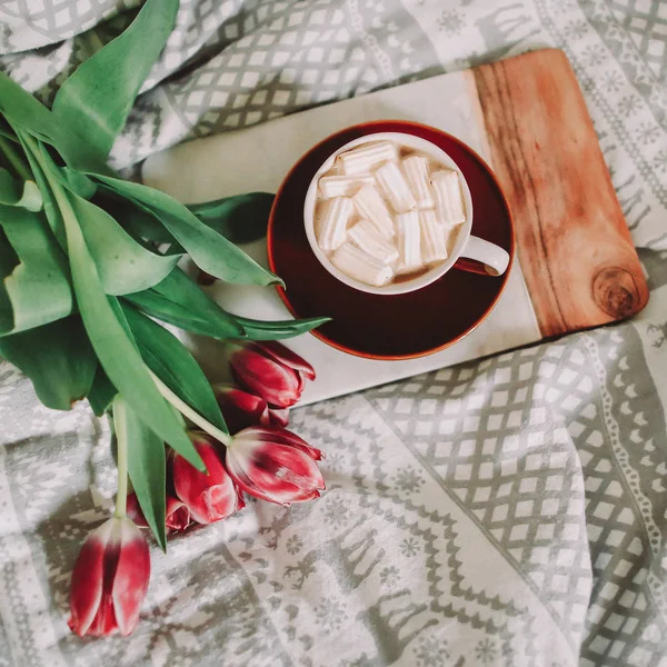 Xícara de café com marshmallows e buquê de tulipas na cama. Conceito de férias, aniversário, Páscoa, Dia Internacional da Mulher. flatlay — Fotografia de Stock