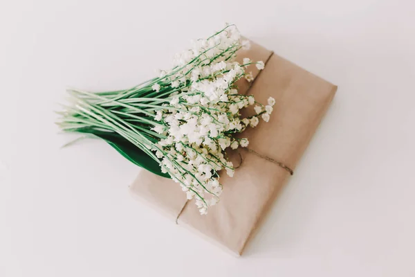 gift box with lilies of the valley on white background. Concept of holiday, birthday, International WomensDay