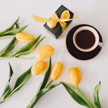 Beyaz arka planda bir buket lale olan bir hediye kutusu. Üst Manzara Düzlüğü. Doğum günü kavramı, Paskalya, Uluslararası Kadınlar Günü