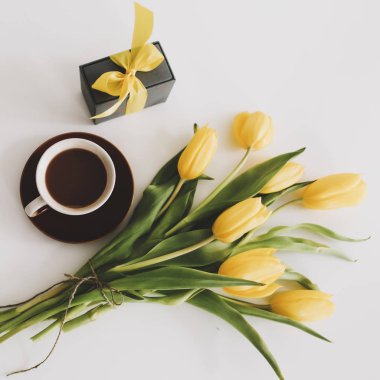 Beyaz arka planda bir buket lale olan bir hediye kutusu. Üst Manzara Düzlüğü. Doğum günü kavramı, Paskalya, Uluslararası Kadınlar Günü