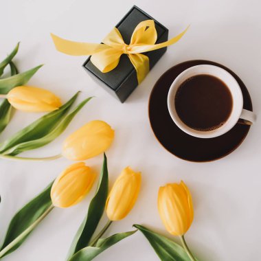 Beyaz arka planda bir buket lale olan bir hediye kutusu. Üst Manzara Düzlüğü. Doğum günü kavramı, Paskalya, Uluslararası Kadınlar Günü