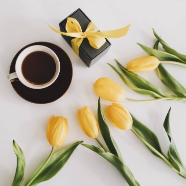 Beyaz arka planda bir buket lale olan bir hediye kutusu. Üst Manzara Düzlüğü. Doğum günü kavramı, Paskalya, Uluslararası Kadınlar Günü