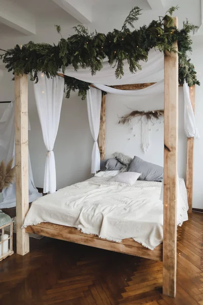 Nowoczesny wystrój wnętrz. Łóżko z drewnianym baldachimem i poduszkami, koc. Wnętrze sypialni w skandynawskim stylu. Wystrój domu. — Zdjęcie stockowe