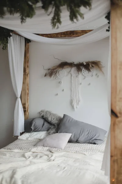 Modern interieur. Bed met houten luifel en kussens, deken. Slaapkamer interieur, Scandinavische stijl. Home decor. — Stockfoto