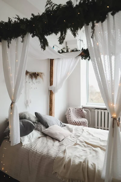 Nowoczesny wystrój wnętrz. Łóżko z drewnianym baldachimem i poduszkami, koc. Wnętrze sypialni w skandynawskim stylu. Wystrój domu. — Zdjęcie stockowe