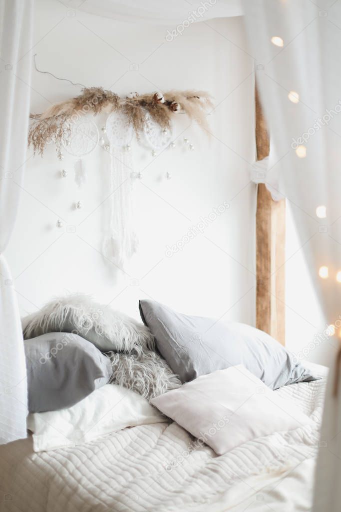 Modern home interior design. Bed with wooden canopy and pillows, blanket. Bedroom interior, scandinavian style. Home decor. 