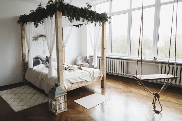 Przestronna sypialnia z drewnem, kocami i łóżkiem pod ścianą. Nowoczesna koncepcja wnętrz domowych. — Zdjęcie stockowe