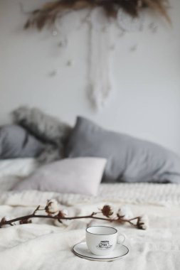 Kahve fincanı ve pamuk çiçeği. Yatakta kahvaltı. Rahat bir ev. düz, durgun hayat.