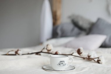 Kahve fincanı ve pamuk çiçeği. Yatakta kahvaltı. Rahat bir ev. düz, durgun hayat.