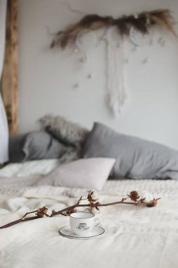 Kahve fincanı ve pamuk çiçeği. Yatakta kahvaltı. Rahat bir ev. düz, durgun hayat.