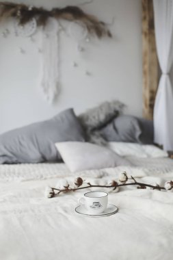 Kahve fincanı ve pamuk çiçeği. Yatakta kahvaltı. Rahat bir ev. düz, durgun hayat.