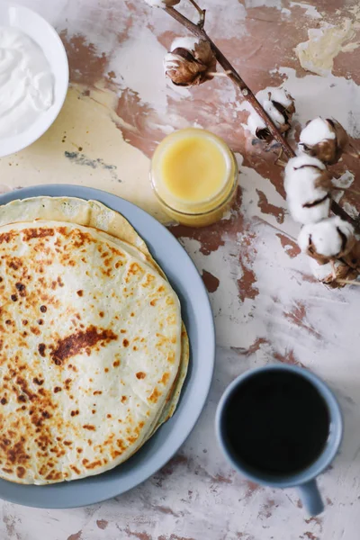 Setumpuk pancake buatan sendiri yang lezat di piring dengan madu, krim asam dan teh. Sarapan. Gaya Rustic, close up top view. Letak rata — Stok Foto