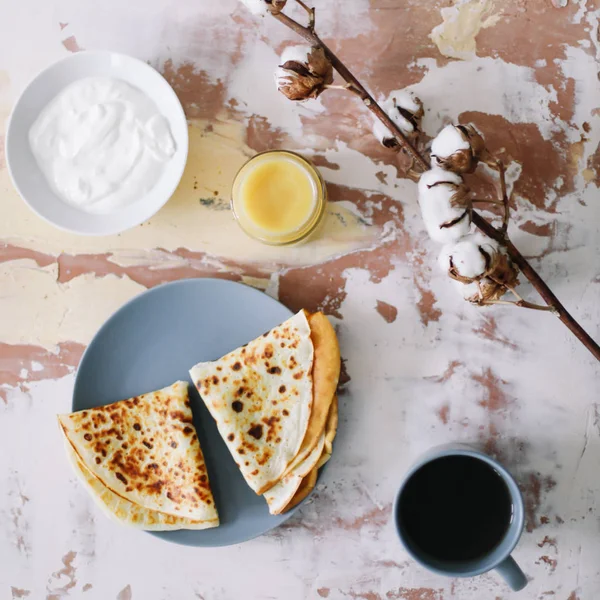 Setumpuk pancake buatan sendiri yang lezat di piring dengan madu, krim asam dan teh. Sarapan. Gaya Rustic, close up top view. Letak rata — Stok Foto