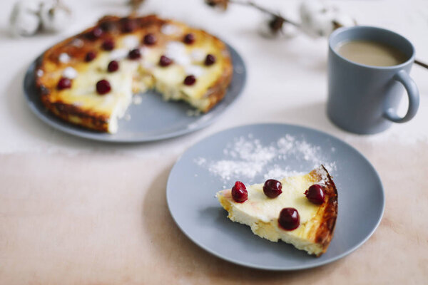 Cottage cheese casserole with berries with cup of coffee on kitchen table. Breakfast concept. Food photography. Table top photo