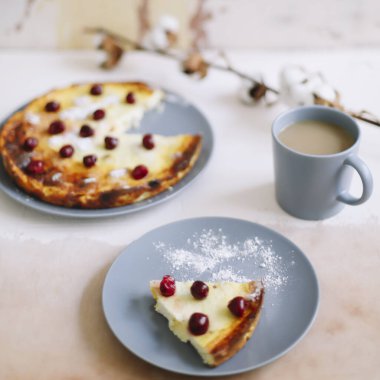 Mutfak masasında bir fincan kahve ve çilekli süzme peynir güveci. Kahvaltı konsepti. Yemek fotoğrafçılığı. Tablo üstü resmi