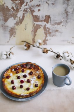 Mutfak masasında bir fincan kahve ve çilekli süzme peynir güveci. Kahvaltı konsepti. Yemek fotoğrafçılığı. Tablo üstü resmi