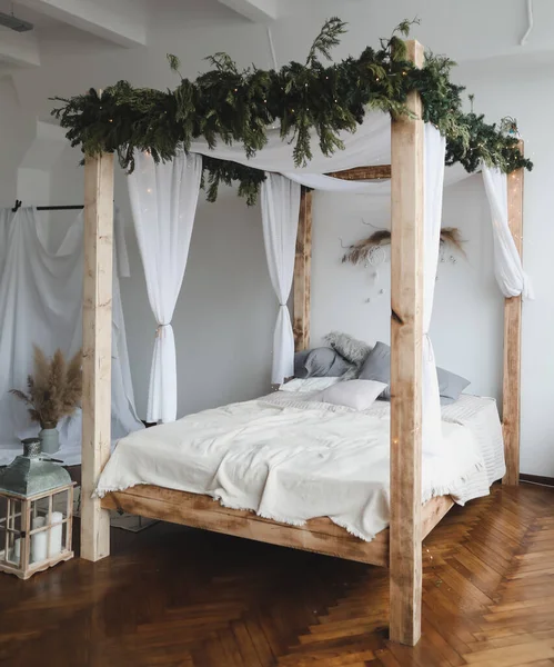 Duvara dayalı yatağı olan geniş bir yatak odası. Tahta tenteli yatak. Modern ev dekorasyonu konsepti. İskandinav tarzı — Stok fotoğraf