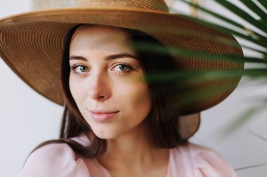 Elbise giymiş oldukça mutlu genç bir kadın. Şapkalı, gülümseyen güzel bir kız. Romantik çekim. Bahar kadınlarının moda fotoğrafı.