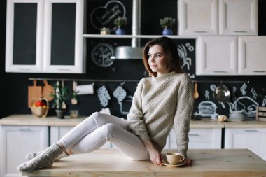 Evdeki mutfakta kahve içen bir kız. Elinde bir fincan kahve tutan genç bir kadın. Kafede içki içen bir kız. Günaydın.. 