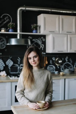 Evdeki mutfakta kahve içen bir kız. Elinde bir fincan kahve tutan genç bir kadın. Kafede içki içen bir kız. Günaydın.. 