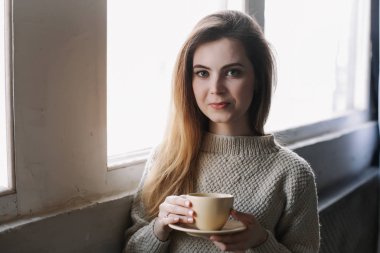 Evdeki mutfakta kahve içen bir kız. Elinde bir fincan kahve tutan genç bir kadın. Kafede içki içen bir kız. Günaydın.. 