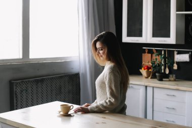 Evdeki mutfakta kahve içen bir kız. Elinde bir fincan kahve tutan genç bir kadın. Kafede içki içen bir kız. Günaydın.. 