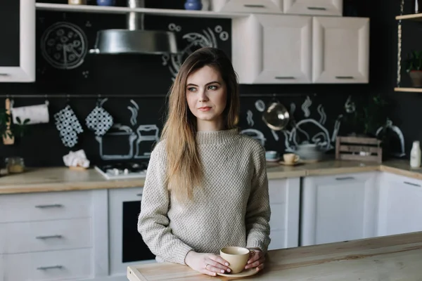 Een meisje dat thuis koffie drinkt in de keuken. Jonge vrouw met een kop koffie. Meisje drinkt drank in café. Goedemorgen.. — Stockfoto