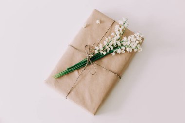 Beyaz arka planda vadi zambaklarıyla dolu güzel bir hediye kutusu. Tatil, doğum günü, kadınlar günü kavramı. düz yat