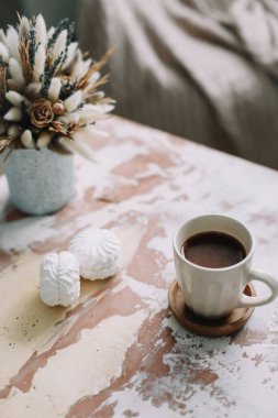 Çiçekli kahve fincanı. Kaliteli düz yatak. Ev dekorasyonu. Samimi sıcak görüntü, hygge biçimi