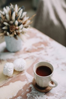 Çiçekli kahve fincanı. Kaliteli düz yatak. Ev dekorasyonu. Samimi sıcak görüntü, hygge biçimi