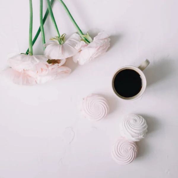 Pink rose flowers, coffee and marshmallows on a white background. Flowers composition. Wallpaper, Flat lay, top view, copy space.