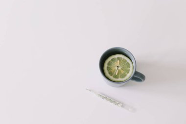Virüs önleme ve tedavi. Limonlu çay ve termometre. Coronavirus COVID-19 geçmişi. Boşluğu kopyala, üst görünüm