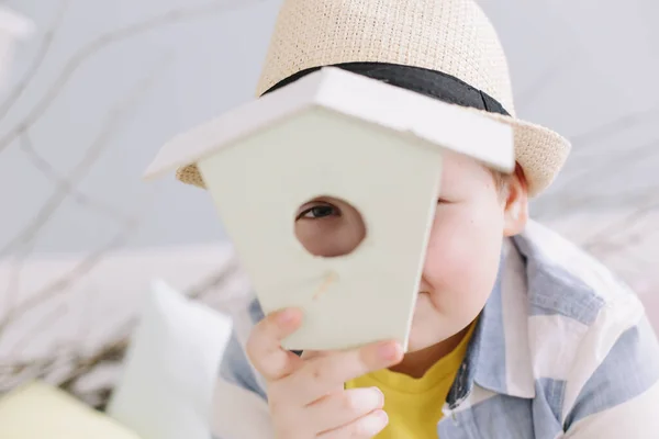 Närbild porträtt av en pojke i en hatt som håller torra pilkvistar. Begreppet vår och påsk. — Stockfoto