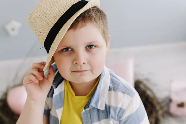 Närbild porträtt av en pojke i en hatt som håller torra pilkvistar. Begreppet vår och påsk. — Stockfoto