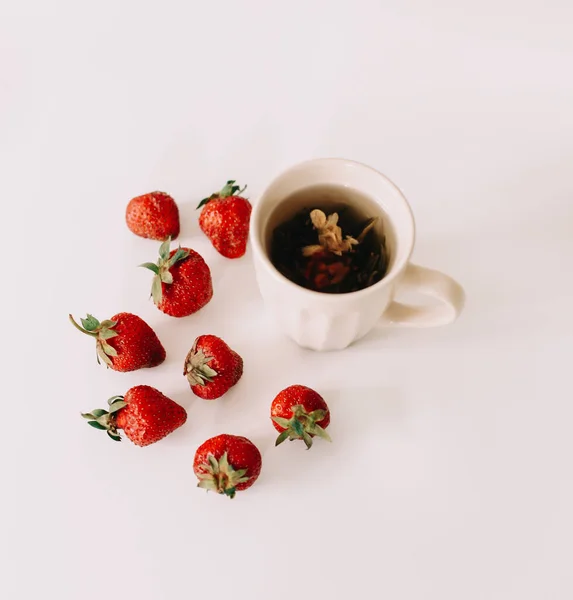 Green tea with strawberries on a white background. Flat lay, top view