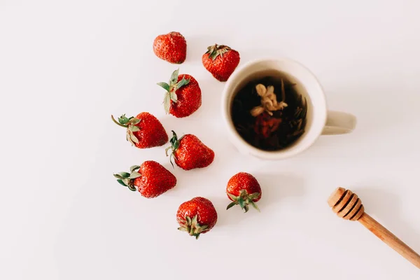 Green tea with strawberries on a white background. Flat lay, top view