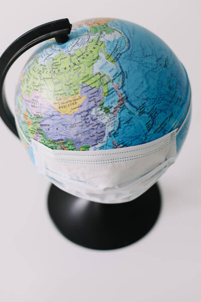 Концепция коронавируса. Мир или земля надевают маску для борьбы с коронавирусом. Концепция борьбы с вирусом. Ковид-19
.