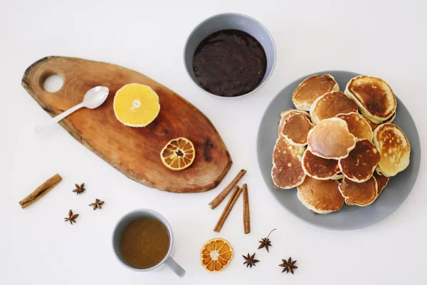 Üppige Pfannkuchen und Teekanne mit Gewürzen, Tasse Tee mit Orange, Zimt, Anis. Leckeres Frühstück auf weißem Hintergrund. Guten Morgen — Stockfoto