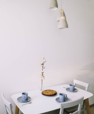 Tabakta bir parça turta ve beyaz masada bir fincan çay. Çay ve pastayla kahvaltı. Yemek fotoğrafçılığı. Masanın üstündeki fotoğraf. Çay zamanı.