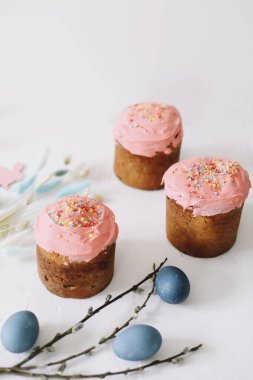 Paskalya pastaları, boyanmış yumurtalar ve ağaç dallarıyla dolu bir Paskalya masası. Kulich kremayla süslenmiş. Mutlu Paskalyalar