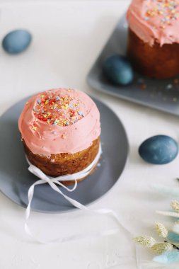 Paskalya pastaları, boyanmış yumurtalar ve ağaç dallarıyla dolu bir Paskalya masası. Kulich kremayla süslenmiş. Mutlu Paskalyalar