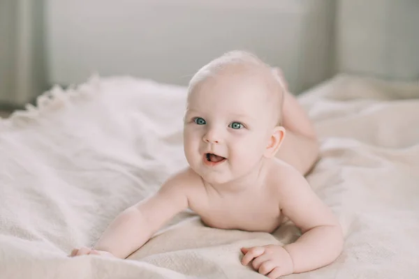 健康的婴儿在床上。可爱快乐的小女孩坐着玩耍。一个漂亮的女婴的肖像。童年、婴儿保育概念 — 图库照片