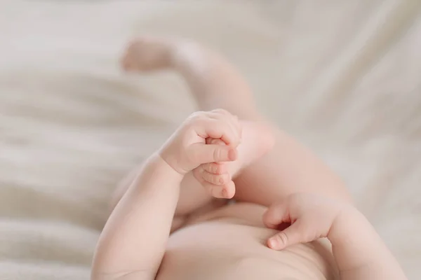 Bambino che gioca con i piedi. Infanzia, famiglia felice, concetto di cura del bambino. primo piano foto . — Foto Stock