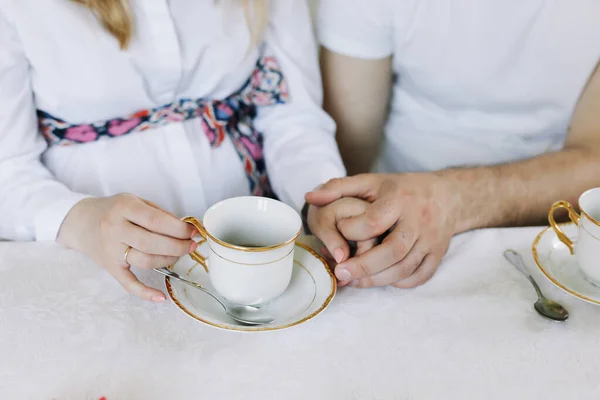 Händer av lyckliga par dricker varmt te hemma. Glad familjelunch. händerna på älskare som dricker te. frukost hemma — Stockfoto