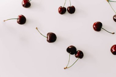 Beyaz arka planda izole edilmiş kirazlar. Düz yatış, üst görünüm.