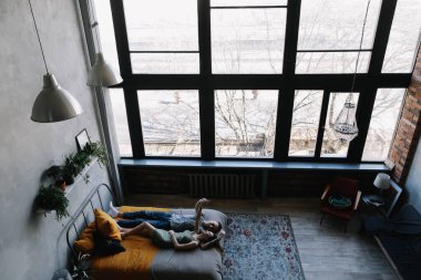 Yatakta yatan genç ve güzel bir çift. Erkek ve kadın yatakta kucaklaşıyorlar. Gençler sırılsıklam aşık. Öpüşen çift portresi. 